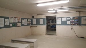 Blick vom Themenraum Bunkergeschichte durch den Mauerdurchbruch in den Themenraum Bunkerleben.