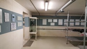 Links die Themenwand zum Warndienst in Westdeutschland, am rechten Bildrand die aufgebauten Krankenbetten.