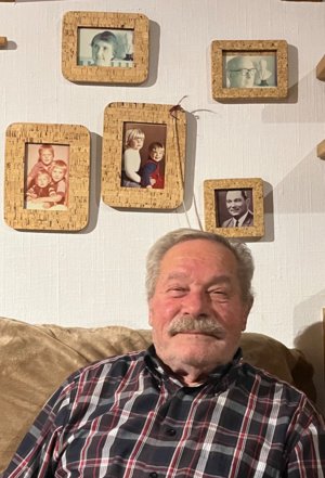 Claudes Sohn Bernard im November 2025. Hinter ihm rechts ein Foto seines Vaters und darüber ein Foto seines Großvaters Maxime.